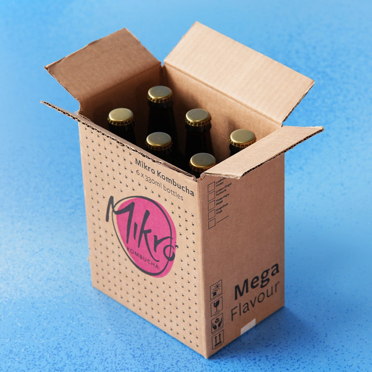 Cardboard box labelled Mikro kombucha with 6 bottles on a blue background
